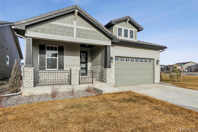 craftsman-style house featuring a front lawn, covered porch, and a garage