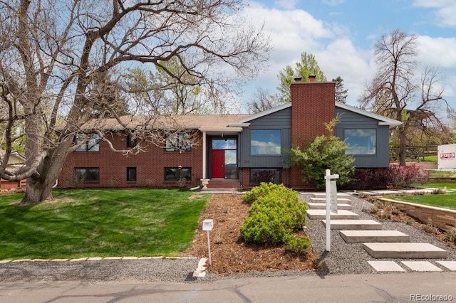 split foyer home with brick siding, a chimney, and a front yard