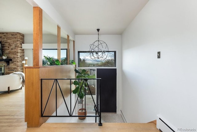 interior space with baseboard heating, wood finished floors, and a chandelier