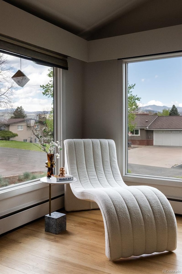 sitting room with plenty of natural light, lofted ceiling, and wood finished floors