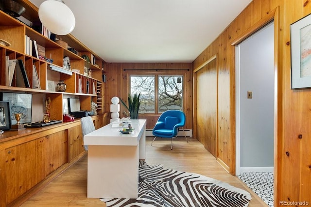 office featuring light wood finished floors, a baseboard heating unit, and wood walls