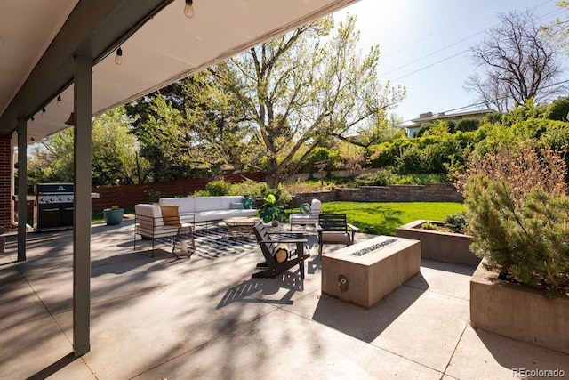 view of patio featuring fence and an outdoor living space with a fire pit