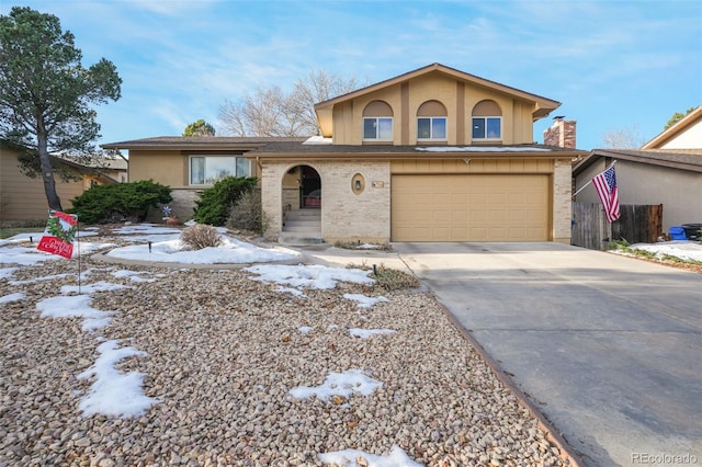 view of front facade featuring a garage, concrete driveway, brick siding, and stucco siding