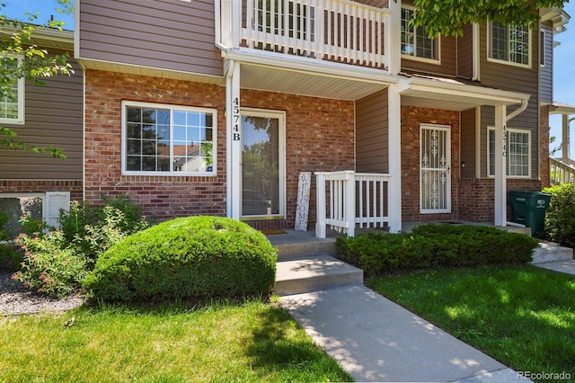 4574 S Cimmarron Cir Unit B, Aurora, CO 80015 - doorway to property with brick siding, a balcony, and a porch