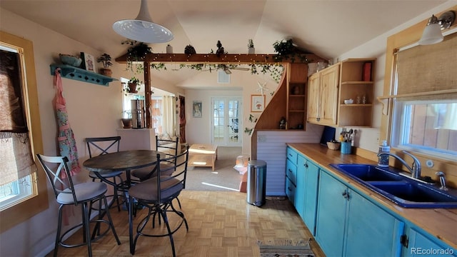 8211 Rocky Mountain Dr, Lakewood, CO 80214 - kitchen with blue cabinets, vaulted ceiling, open shelves, and plenty of natural light
