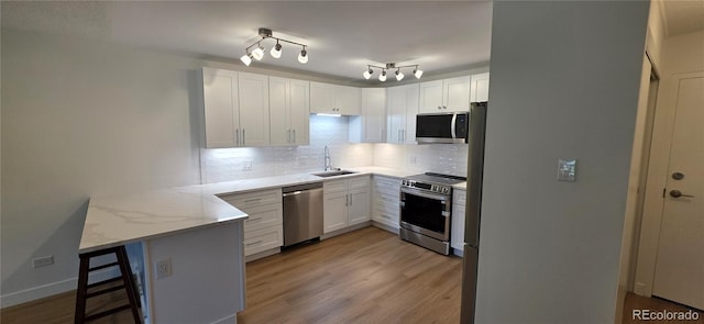 775 S Alton Way Unit 4A, Denver, CO 80247 - kitchen with a peninsula, appliances with stainless steel finishes, decorative backsplash, and white cabinets
