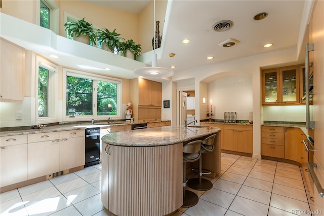 400 S Steele St Unit 13, Denver, CO 80209 - kitchen featuring backsplash, light stone countertops, a kitchen island, light tile patterned flooring, and recessed lighting