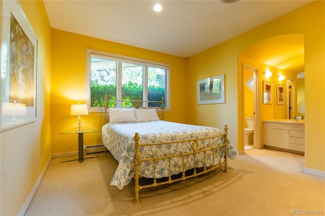 400 S Steele St Unit 13, Denver, CO 80209 - carpeted bedroom featuring a baseboard heating unit, ensuite bath, and arched walkways