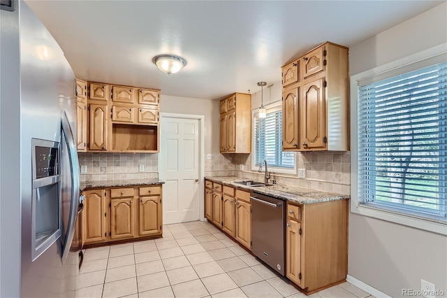 kitchen with appliances with stainless steel finishes, light tile patterned floors, sink, and tasteful backsplash