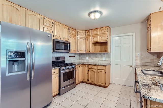 kitchen with appliances with stainless steel finishes, light brown cabinets, decorative backsplash, and sink