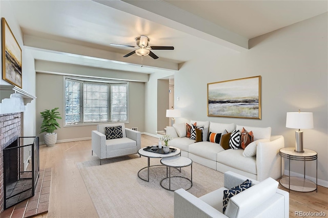 living room featuring a fireplace, ceiling fan, and light wood-type flooring