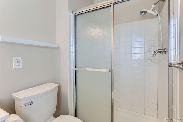 bathroom featuring toilet and an enclosed shower