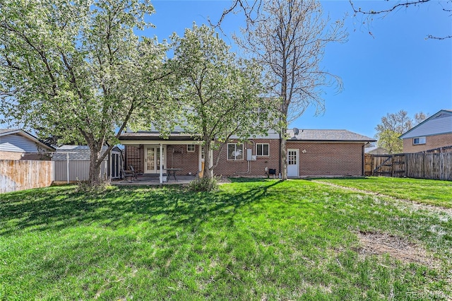 rear view of house with a patio and a lawn