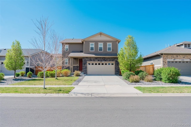 view of front of property featuring fence, stone siding, a garage, a front yard, and concrete driveway