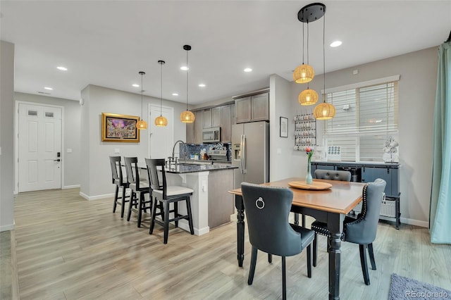 dining space featuring recessed lighting, baseboards, and light wood-type flooring