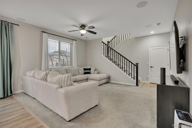 living area with visible vents, stairs, ceiling fan, and baseboards