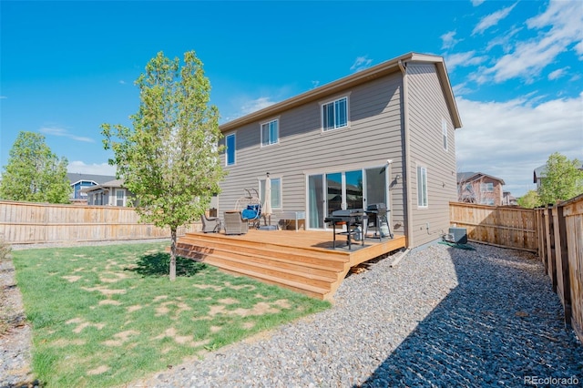 back of house featuring a fenced backyard, a wooden deck, a yard, and central AC