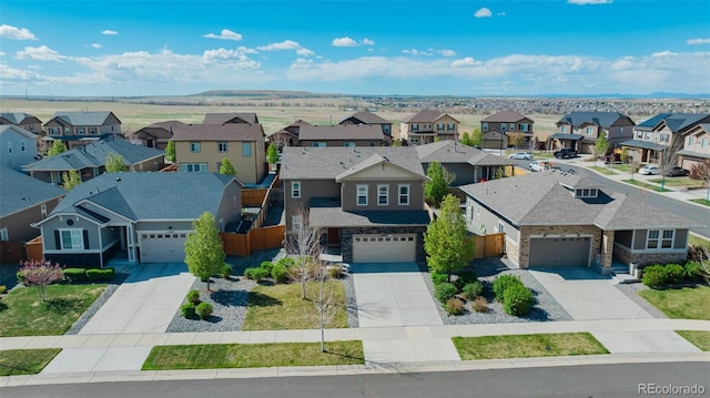 exterior space with a garage, driveway, stone siding, and a residential view