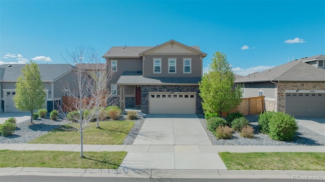 view of front of home featuring fence, an attached garage, driveway, and stone siding