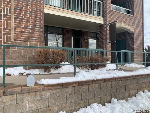 exterior space featuring brick siding and a balcony