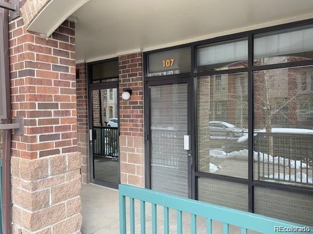 doorway to property featuring brick siding