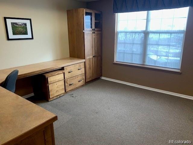 unfurnished office featuring carpet flooring and baseboards