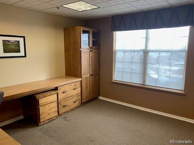 unfurnished office with baseboards, light carpet, and a drop ceiling