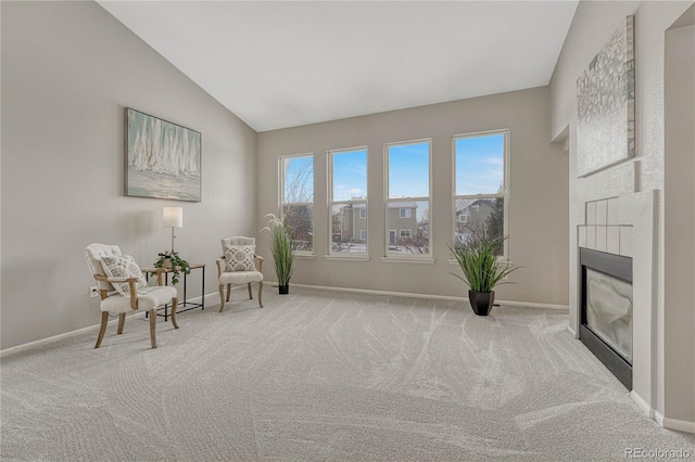 sitting room with a fireplace, vaulted ceiling, and light carpet