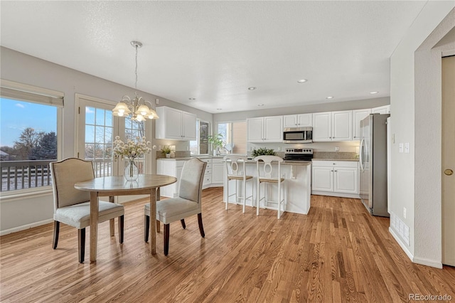 dining room with a chandelier and light hardwood / wood-style floors