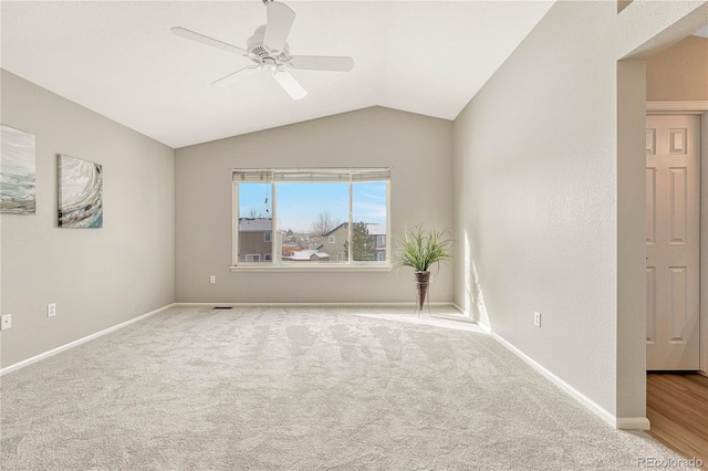 carpeted empty room featuring ceiling fan and lofted ceiling