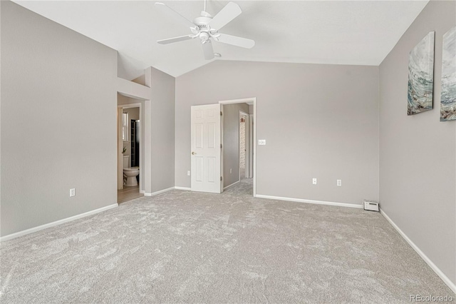 unfurnished bedroom featuring ceiling fan, lofted ceiling, connected bathroom, and light carpet