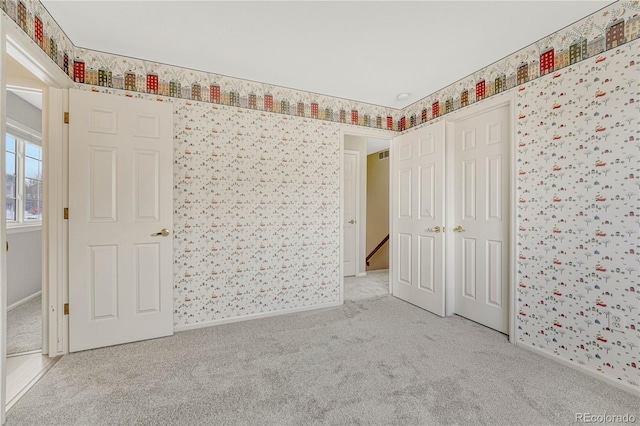 unfurnished bedroom featuring light carpet and a closet