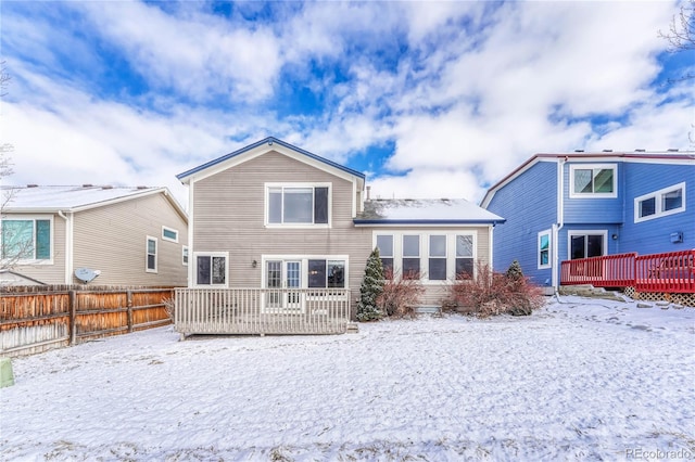 snow covered house featuring a deck