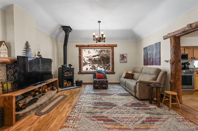 27802 Shadow Mountain Dr, Conifer, CO 80433 - living room featuring a wood stove, light wood-type flooring, a chandelier, and lofted ceiling