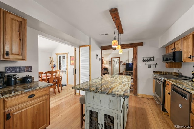 27802 Shadow Mountain Dr, Conifer, CO 80433 - kitchen with stainless steel appliances, dark stone countertops, light wood-style flooring, pendant lighting, and a kitchen island