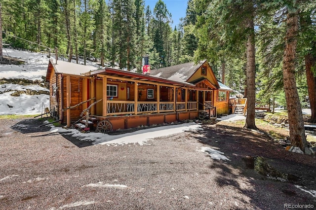 27802 Shadow Mountain Dr, Conifer, CO 80433 - view of front facade featuring a porch and log veneer siding