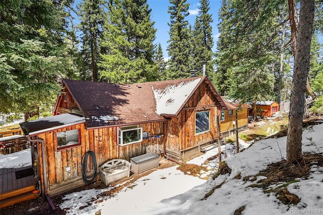 27802 Shadow Mountain Dr, Conifer, CO 80433 - snow covered back of property featuring board and batten siding