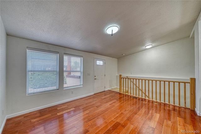 foyer with lofted ceiling, a textured ceiling, and hardwood / wood-style flooring