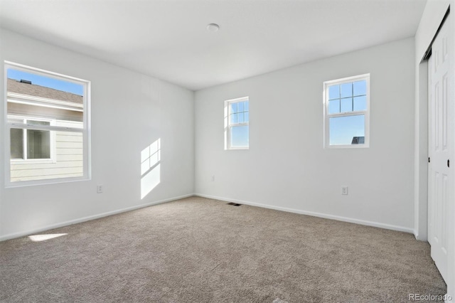 carpeted empty room featuring plenty of natural light