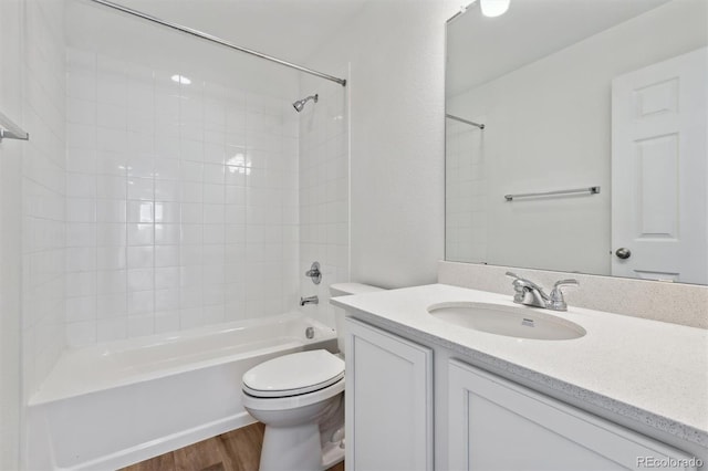 full bathroom with toilet, tiled shower / bath, vanity, and wood-type flooring