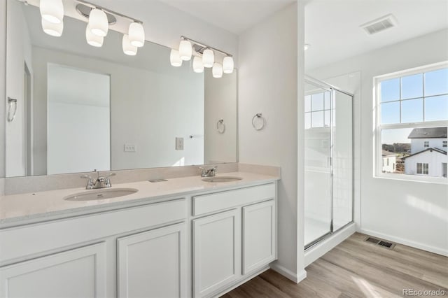 bathroom with vanity, an enclosed shower, and hardwood / wood-style flooring