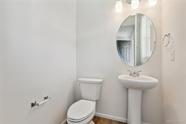 bathroom with sink, hardwood / wood-style floors, and toilet