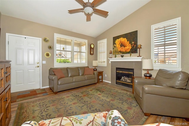 living room with ceiling fan, vaulted ceiling, hardwood / wood-style flooring, and a fireplace