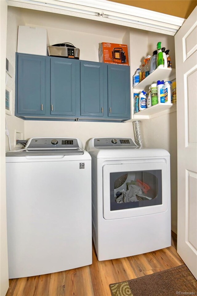 laundry area featuring light hardwood / wood-style flooring, cabinets, and washer and dryer