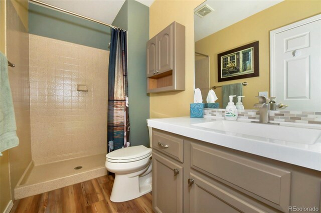 bathroom with hardwood / wood-style flooring, toilet, a shower with shower curtain, and vanity