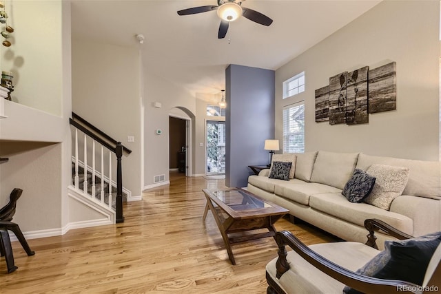 3120 Redhaven Way, Highlands Ranch, CO 80126 - living room with a ceiling fan, arched walkways, stairway, baseboards, and light wood finished floors