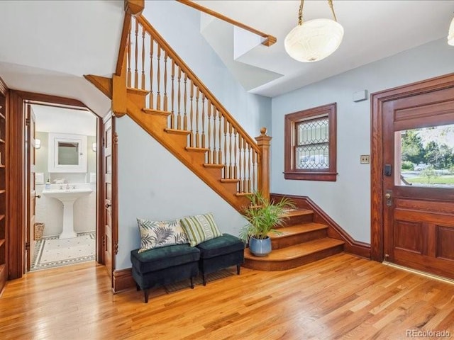 entryway featuring stairway, wood finished floors, and baseboards