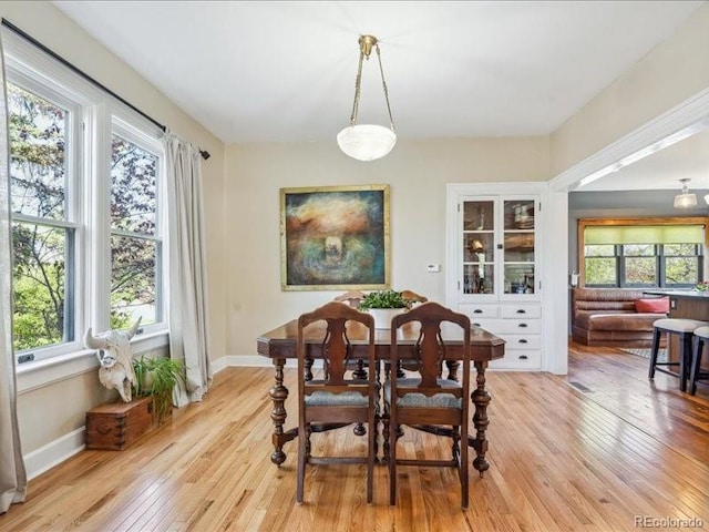dining room featuring light wood finished floors and baseboards