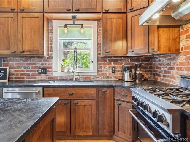 kitchen featuring extractor fan, stainless steel appliances, brown cabinetry, and dark stone counters