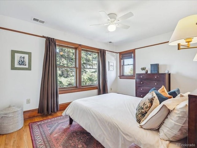 bedroom with wood finished floors, baseboards, and ceiling fan